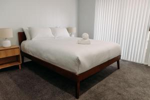 a bedroom with a large bed with white sheets at The Retreat on Piper in Tamworth