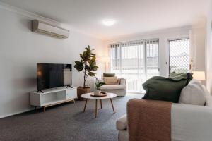 a living room with a couch and a tv at The Retreat on Piper in Tamworth