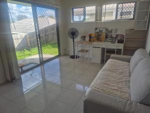 a living room with a couch and a table and a kitchen at One Bedroom One Bathroom Unit With a New TV in Wulkuraka +1 photo