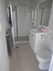 a bathroom with a toilet and a sink and a shower at One Bedroom One Bathroom Unit With a New TV in Wulkuraka