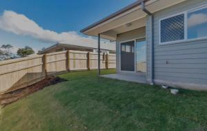 a backyard with a fence and a house at One Bedroom One Bathroom Unit With a New TV in Wulkuraka