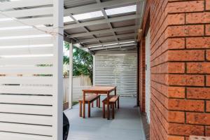 a patio with a table and chairs and a brick wall at The Retreat on Piper in Tamworth