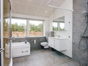 a bathroom with a toilet and a sink and a shower at Saltum Beach Luxury & Wellness in Saltum +16 photos