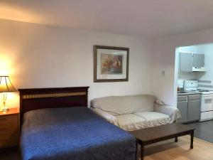 a bedroom with a bed and a couch and a table at Marland Motel in Powell River +23 photos