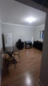 an empty living room with a table and a refrigerator at Casa inteira, Nações in Patrocínio