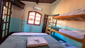 a bedroom with two bunk beds and a window at Almar Hospedagem 2 ARRAIAL DO CABO in Arraial do Cabo