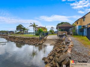 a body of water next to a building at Iluka Villa 2 in Iluka