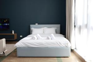 a bedroom with a white bed with two towels on it at Palm Vista Retreat in Durrës