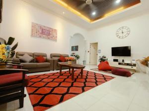 a living room with a couch and a table at Redhousehomestay in Kota Bharu