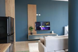a living room with a white couch and a tv at Palm Vista Retreat in Durrës