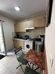 a kitchen with a table and a stove and a washer at Studio Kastra in Thessaloniki