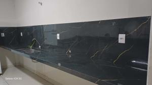 a bathroom with a black marble counter with a sink at Happy day chácaras in Uberlândia