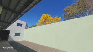 a white wall with trees in the background at Happy day chácaras in Uberlândia