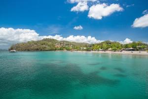 a view of a beach with a boat in the water at Bungalow PunchCoco - Beachfront in Les Trois-Îlets