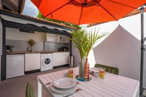 a dining table with an orange umbrella in a kitchen at Bungalow PunchCoco - Beachfront in Les Trois-Îlets