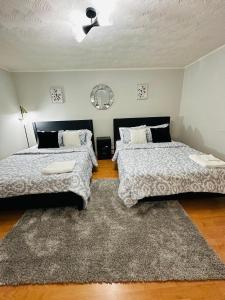 a bedroom with two beds and a rug at Cozy Private Apartment with 2 Queen size Beds in Moncton