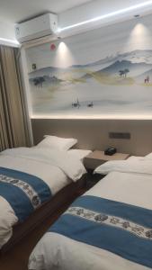 two beds in a room with a mural on the wall at 太溪民宿 in Zhangjiajie Hehua Airport