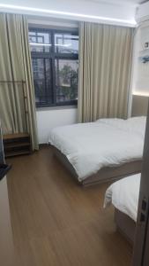 a bedroom with two beds and a window at 太溪民宿 in Zhangjiajie Hehua Airport