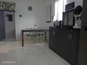 a kitchen with a table and chairs and a microwave at Homestay Atok Mus'lim Only in Jenjarum