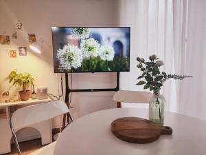 a living room with a table with a vase of flowers at 스테이일룸 in Sŭngch'ŏn-ni