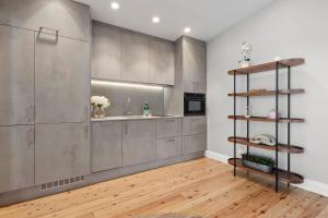 a kitchen with stainless steel cabinets and a sink at The Treehouse Avalon in Whale Beach