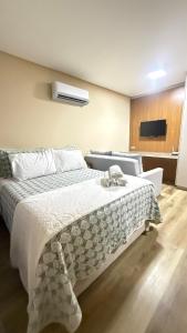 a bedroom with a bed with a comforter on it at Studio no centro de Pomerode! in Pomerode