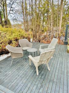 three chairs and a table on a wooden deck at Cozy Private Apartment with 2 Queen size Beds in Moncton