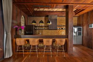 a kitchen with a bar with stools at Royal Roco Villa in Tanah Lot