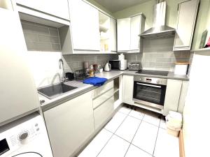a small kitchen with white cabinets and a sink at meze in Perth +7 photos