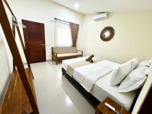 a bedroom with a bed and a chair in it at Kapal Dream Homestay in Selong Belanak