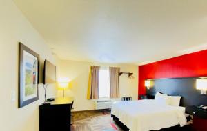a hotel room with a white bed and a red wall at Black Gold Suites Tioga in Tioga +12 photos