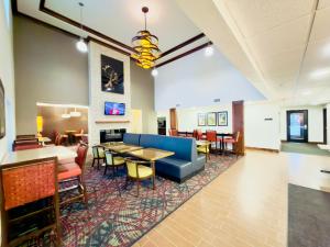 a lobby with a couch and tables and chairs at Black Gold Suites Tioga in Tioga
