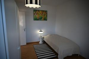 a bedroom with a bed with a lamp and a painting at TheCrown in Kilchberg +3 photos