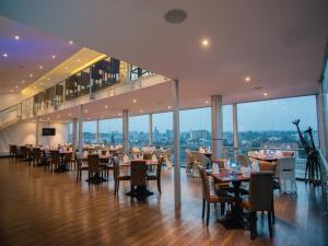 a dining room with tables and chairs and windows at Cloud Hotel & Suites in Nairobi
