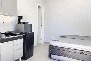 a kitchen with a stove and a bed in a room at Studio III - Centro Jundiaí - Ar Condicionado in Jundiaí