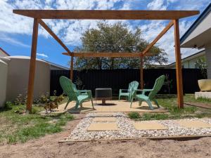a group of green chairs sitting on a patio at Lahool Cottage in Stanthorpe