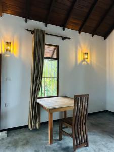 a table and a chair in a room with a window at Dacha Retreat in Midigama East