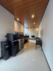 a kitchen with a black refrigerator and a table at Griya Becik Lovina - Private Pool Villa near Lovina Dolphin Spot in Lovina