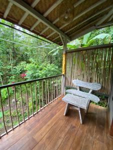 a wooden porch with a bench on a wooden deck at Seenau House Bali in Selemadeg