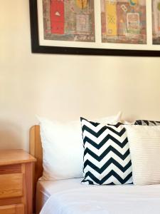 a bed with a black and white pillow and a picture at Tayafut ApartmentTerrace in Mirleft