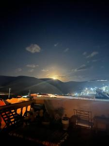 a view of a city at night with the sun setting at Tayafut ApartmentTerrace in Mirleft +20 photos