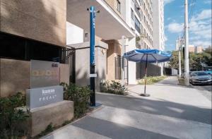 a building with a sign and an umbrella on a sidewalk at Studio - Quaddra Butantã NOVÍSSIMO MODERNO - Academia - Piscina - 5min Metrô e USP in São Paulo