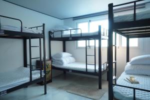 a room with three bunk beds and a window at NamSan203 Guest house in Seoul