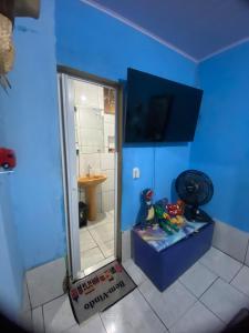 a bathroom with a mirror and a blue wall at flat temporada in Goiânia