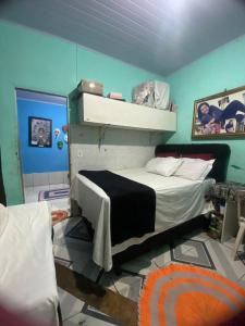 a bedroom with a bed and a blue wall at flat temporada in Goiânia