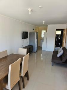 a dining room and living room with a table and chairs at Cabañas del cerro sombrero in Arica