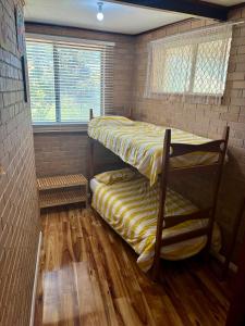 two bunk beds in a room with wood floors at Kite House in Guilderton