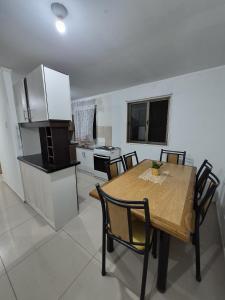 a kitchen with a wooden table and chairs in a room at Cabañas del cerro sombrero in Arica