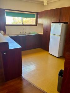 a kitchen with a white refrigerator and a window at Kite House in Guilderton +6 photos