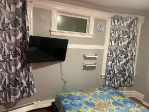a bedroom with a bed and a television on the wall at Grove#9 in Irvington